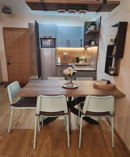 a kitchen and dining room with a wooden table and chairs at bloom_apartman in Zlatibor