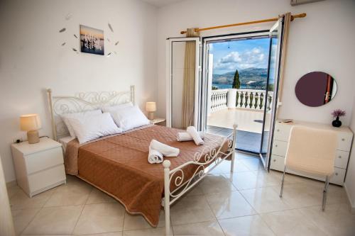 een slaapkamer met een bed en een glazen schuifdeur bij Nikos Apartments Spacious and Panoramic in Argostoli