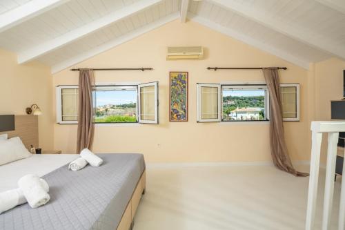 a bedroom with two beds and two windows at Premier Tsilivi in Tsilivi