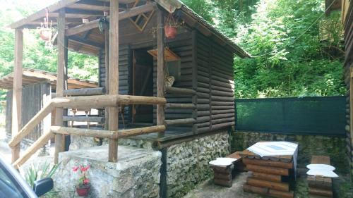 a wooden cabin with a staircase in a yard at Apartmani Dada Kanjon Grmuša in Bihać