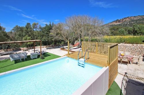 a swimming pool in a backyard with a table and chairs at Villa Son Pons by Slow Villas in Llucmajor
