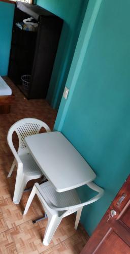 un tavolo bianco e due sedie accanto a una parete blu di Casa Costa Azul a Uvita