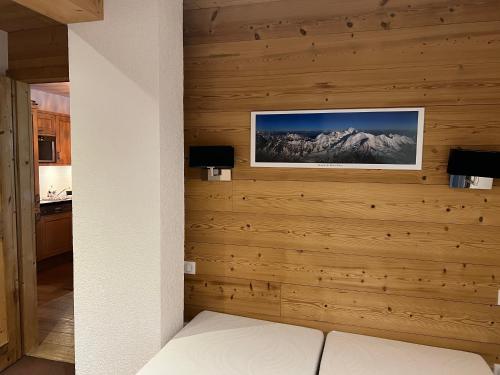 Un dormitorio con una pared de madera con una imagen de montaña en Large premium alpine apartment for 4 to 8 people, en Vallorcine