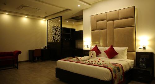 a hotel room with a large bed with red pillows at Rosetum Kasauli in Kasauli