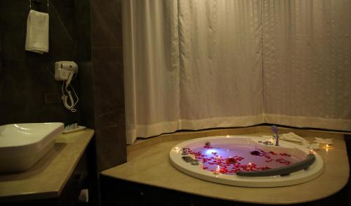 a bathroom with a bath tub with lights in it at Rosetum Kasauli in Kasauli