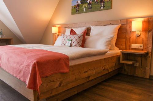 a bedroom with a wooden bed with a red blanket at Hotel & Restaurant Zum Reussenstein in Böblingen