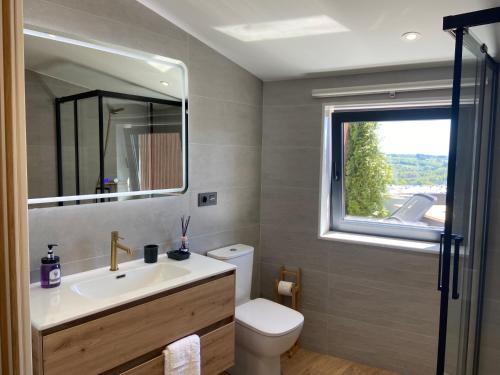 baño con lavabo y aseo y ventana en Siente Muralla en Lugo