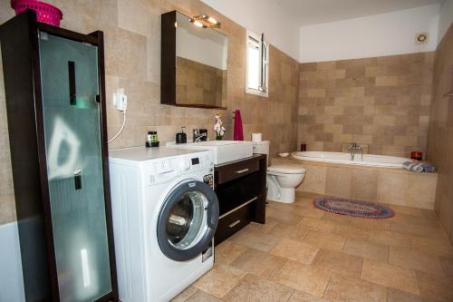 Un baño con lavadora y lavabo. en Nikos Apartments Spacious and Panoramic, en Argostoli