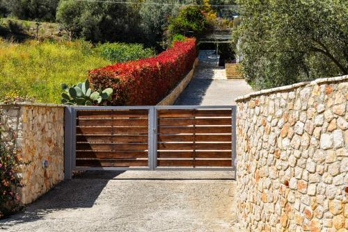 a gate in a garden with red flowers at Belvedere Rare&Peaceful 2BR home+stunning sea view in Tolo