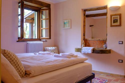 - une chambre avec un lit et un miroir dans l'établissement Le Case Gialle, à Gualdo Cattaneo