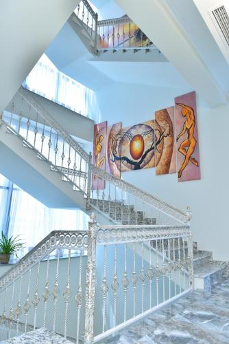 a white staircase with paintings on the walls at Altunyan Hotel in Yerevan