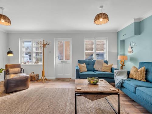 a living room with blue couches and a coffee table at Pass the Keys Stunning 2 Bed House by the Sea in Whitstable