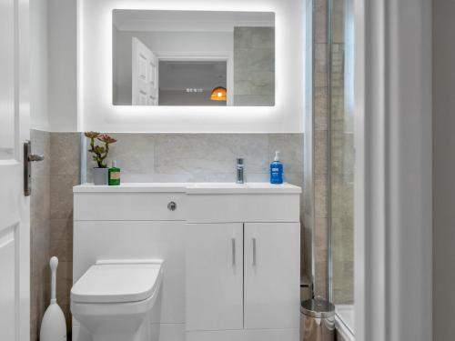 a white bathroom with a sink and a mirror at Pass the Keys Stunning 2 Bed House by the Sea in Whitstable
