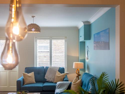 a living room with a blue couch and a window at Pass the Keys Stunning 2 Bed House by the Sea in Whitstable