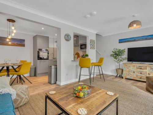 a living room with a table and yellow chairs at Pass the Keys Stunning 2 Bed House by the Sea in Whitstable