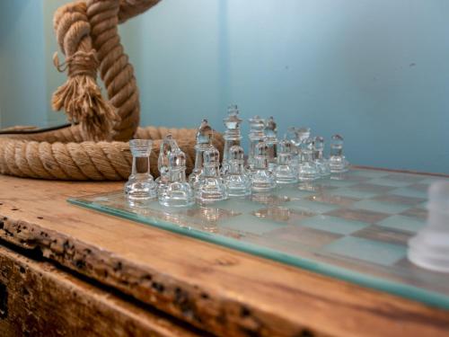a glass chess set on a wooden table at Pass the Keys Stunning 2 Bed House by the Sea in Whitstable