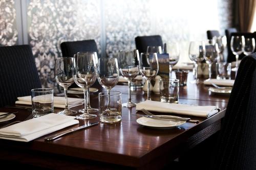 a long wooden table with wine glasses and napkins at Croydon Lodge in Gore