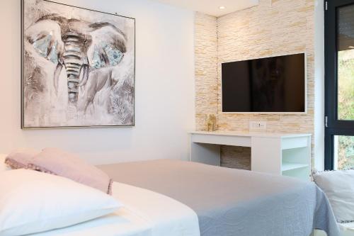 1 dormitorio con 1 cama y TV en la pared en Hedera Estate, Hedera Studio 4, en Dubrovnik