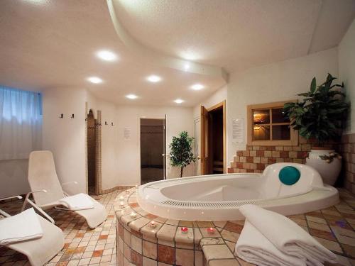 un ampio bagno con una grande vasca in una stanza di HOTEL BOSCO VERDE a Zoldo Alto