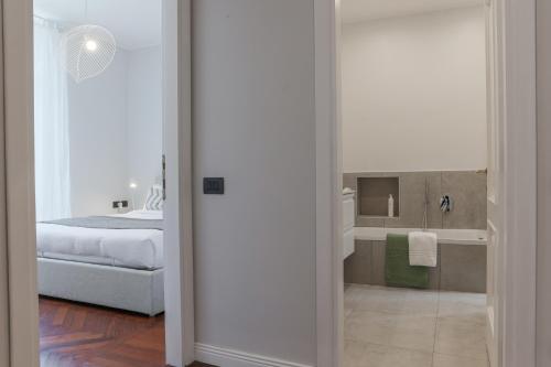 een slaapkamer met een bed en een badkamer met een spiegel bij Como Lake Vista - by MyHomeInComo in Blevio
