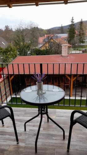 a table on a balcony with a cup on it at Kincsem Vendégház in Szilvásvárad