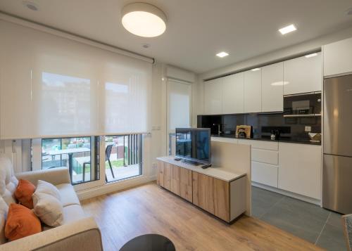 a living room with a couch and a tv at BILBAO COSTA-Algorta-Getxo- A ESTRENAR-parking-playa-metro-BILBAO en metro, a 25 mimutos in Getxo