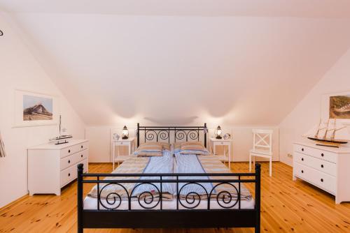 a bedroom with a large bed and white furniture at Landhaus Greetsiel am Hafen "Kapitänsbrücke II" in Krummhörn