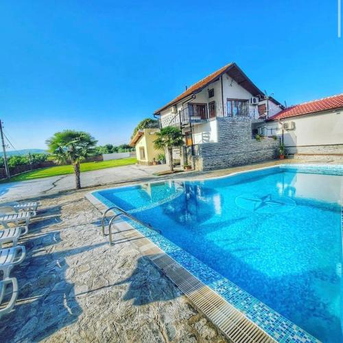 a large swimming pool in front of a house at Хотелски Комплекс Копитото in Tamarino