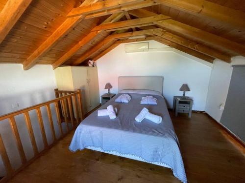 - une chambre mansardée avec un grand lit dans l'établissement Maritina house, à Poúlithra