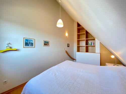 ein Schlafzimmer mit einem großen weißen Bett im Dachgeschoss in der Unterkunft Dünenresidenz Karlshagen - Ferienwohnung Lindenweg 8b in Ostseebad Karlshagen