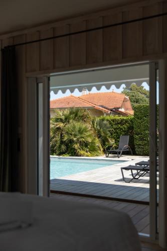 a view of a swimming pool through a sliding glass door at Villa Les Délices in Cap-Ferret