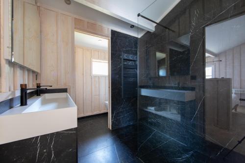 a black bathroom with a sink and a tub at Villa Les Délices in Cap-Ferret
