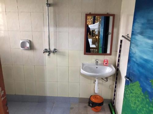 a bathroom with a sink and a mirror at Home stay studio 62 Guesthouse in Jinja