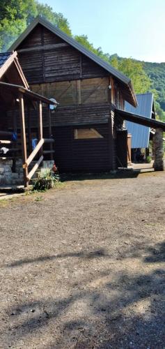 a log cabin with a porch and a building at Apartmani Dada Kanjon Grmuša in Bihać