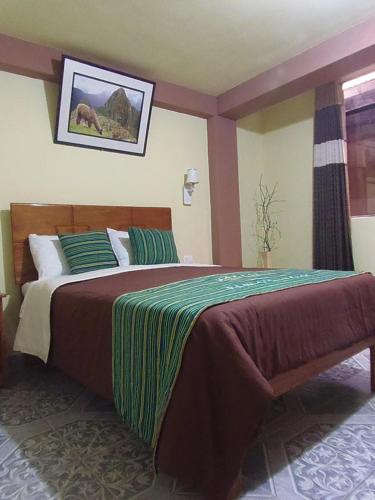 a bedroom with a large bed with green and brown sheets at Hostal Pablo's House in Machu Picchu