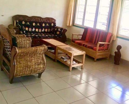 a living room with chairs and a couch and a table at Home stay studio 62 Guesthouse in Jinja