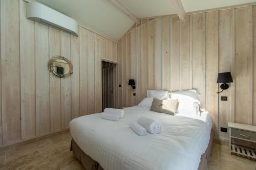 a bedroom with a large white bed with towels on it at Villa Les Délices in Cap-Ferret