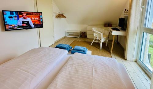 a bedroom with a bed and a tv on the wall at Ferienhäuser mit Seeblick direkt am Plauer See in Plau am See