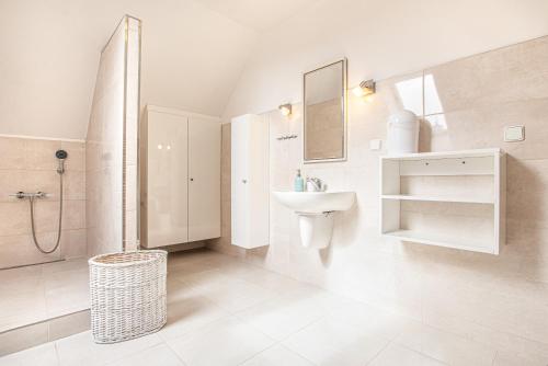 a white bathroom with a sink and a shower at Lichtenštejnské domky in Lednice