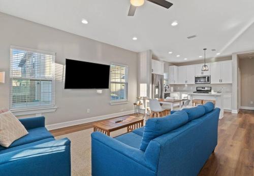 ein Wohnzimmer mit einem blauen Sofa und einer Küche in der Unterkunft Cheerful 3BR close to downtown + double balcony in Pensacola
