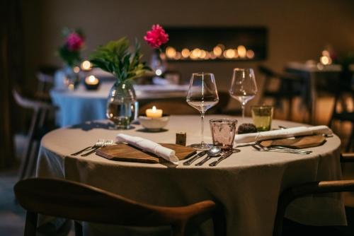 a table with a white table cloth and wine glasses at House Raduha in Luče