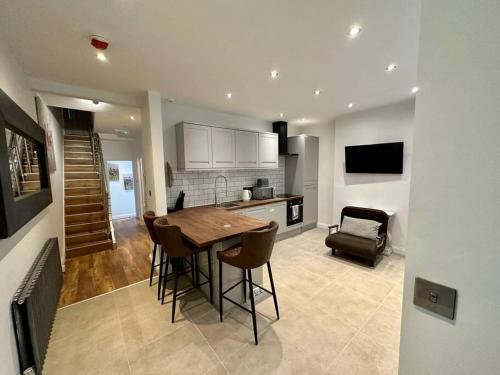uma cozinha e sala de estar com uma mesa de madeira e cadeiras em Stunning 2 bedroom let’s BBQ. em Brighton & Hove