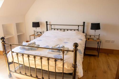 a bed in a bedroom with two lamps and two tables at Osher Apartment in Enniscorthy