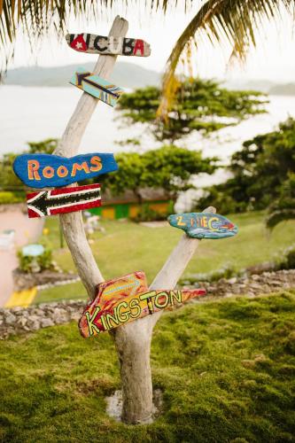 a pole with signs on it in the grass at Galina Breeze in Port Maria