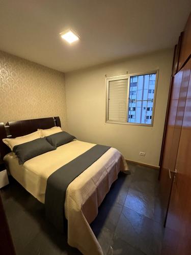 een slaapkamer met een groot bed en een raam bij Apartamento no Setor Bueno - imóvel completo e com excelente localização in Goiânia