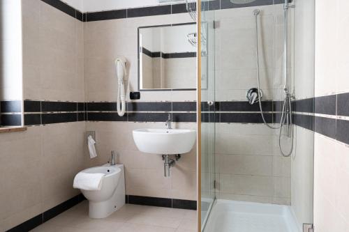 a bathroom with a shower and a sink and a toilet at Hotel Premiere in Marina di Varcaturo