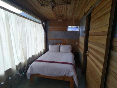 um pequeno quarto com uma cama numa casa em Mamallacta Páramo Lodge em Papallacta