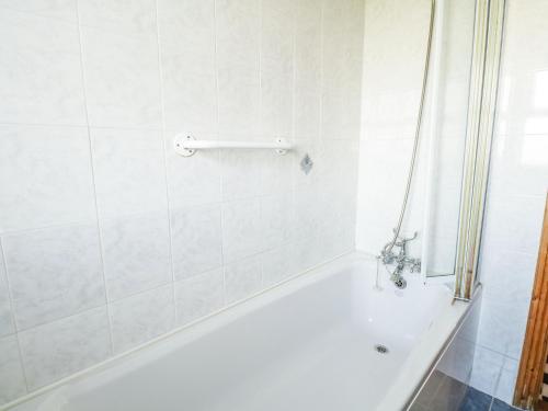 a white bathroom with a tub and a shower at Mullaneys in Enniscrone