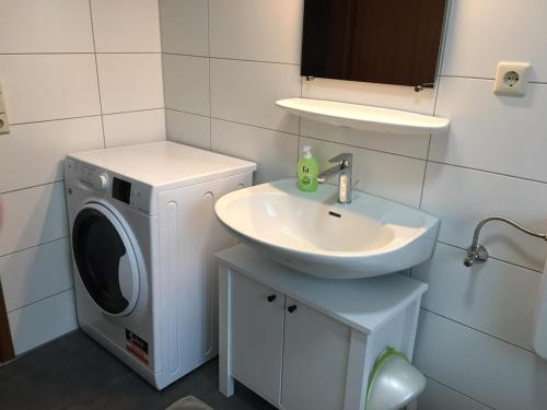 a bathroom with a washing machine and a sink at Ferienhaus Bibernest in Münsingen