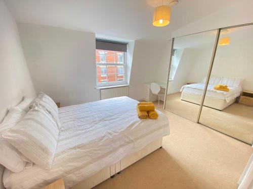 um quarto com uma cama grande e um espelho em Cosy duplex in Central London em Londres